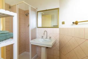a bathroom with a sink and a shower and a mirror at Su Trigu, primo piano in Bari Sardo +16 photos