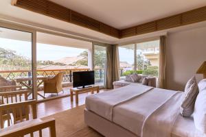 a bedroom with a large bed and a balcony at Mövenpick Resort Aswan in Aswan
