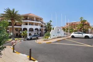 a parking lot with cars parked in front of a building at Hygge Home with Seaside and Golf-View Balcony in San Miguel de Abona