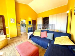 ein Wohnzimmer mit einem blauen Sofa und bunten Kissen in der Unterkunft Attico Porto in Castiglione della Pescaia
