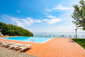 uma piscina com cadeiras e vista para a água em Azzurro Apartment em Padenghe sul Garda