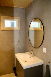 W łazience znajduje się umywalka i lustro. w obiekcie Arctic Home Experience w mieście Äkäslompolo