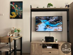 SMG - Studio@Green2: Wi-fi, Netflix, Swim & Relax في Cavite: غرفة معيشة مع تلفزيون بشاشة مسطحة على جدار