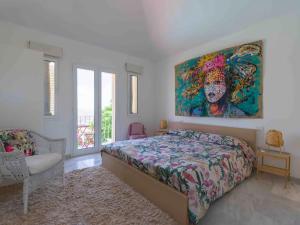 a bedroom with a bed and a painting on the wall at Villa Linda in San Bartolomé de Tirajana +26 photos