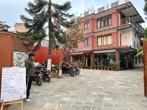 a man standing in front of a building with motorcycles at PS Boutique Hotel in Kathmandu
