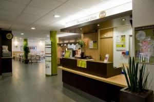 a restaurant with a counter in the middle of a building at B&B HOTEL Paris Le Bourget in Le Bourget