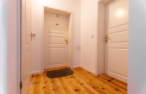 an empty hallway with white doors and a rug at Ferienwohnung in Heringsdorfer Villa Koje in Bansin +11 photos