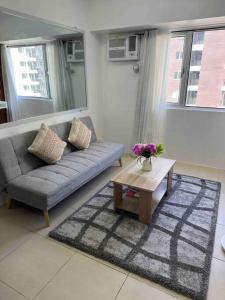 a living room with a couch and a table at Stylish 2Bedroom Unit @Avida #26 in Iloilo City