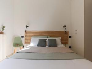 een slaapkamer met een wit bed met 2 kussens bij The Best Rent - Corso Buenos Aires Apartment in Milaan
