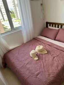 a bedroom with a bed with two hats on it at Stylish 2Bedroom Unit @Avida #26 in Iloilo City