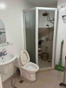 a bathroom with a shower and a toilet and a sink at Stylish 2Bedroom Unit @Avida #26 in Iloilo City