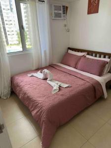 a large bed with two white towels on it at Stylish 2Bedroom Unit @Avida #26 in Iloilo City