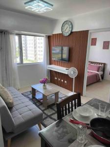 a living room with a couch and a table at Stylish 2Bedroom Unit @Avida #26 in Iloilo City