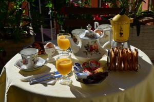 a table with a tea set with glasses of orange juice at B&B SPLENDIDAE MUNDI in Rome