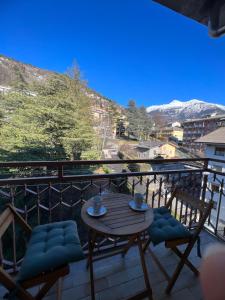 a balcony with a table and chairs and mountains at Blue Moon - Via Parigi Apartments in Aosta