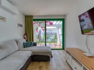 ein Wohnzimmer mit einem Sofa und einer Glasschiebetür in der Unterkunft Elegante apartamento 5 min de playa in San Bartolomé de Tirajana