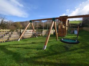 a swing set in the grass in a yard at 3 bed in Blue Anchor 87069 in Withycombe