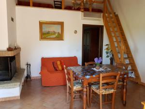 un comedor con mesa y sillas y una escalera en Agriturismo Bio Le 4 Stagioni en Porrona