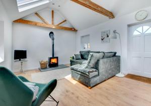 a living room with a couch and a fireplace at Spring House Studio in Alderton