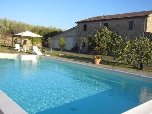una grande piscina blu di fronte a una casa di Agriturismo Bio Le 4 Stagioni a Porrona