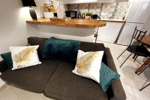 un sofá con almohadas en la sala de estar. en LE CHATEL BOURGEOIS en Appoigny