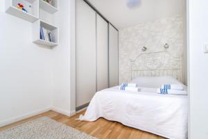 a white bedroom with a white bed with blue accents at Angel House Vilnius, Skroblu 39 in Vilnius