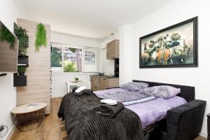a bedroom with a bed and a large painting on the wall at Super Studio Moderne et Cozy Cannes Proche Croisette & Mer in Cannes