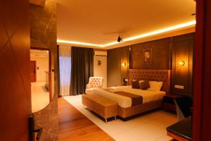KānnangādHotel Classico International的一间带床和椅子的酒店房间