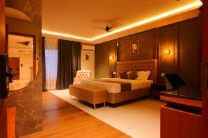 KānnangādHotel Classico International的一间带床和椅子的酒店房间
