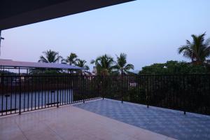 una valla negra con piscina y palmeras en Hotel Classico International en Kānnangād