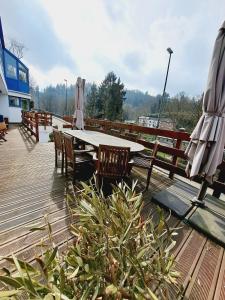 una terrazza in legno con tavolo e sedie. di Gite Villa le Monde - La Roche-en-Ardenne a La-Roche-en-Ardenne