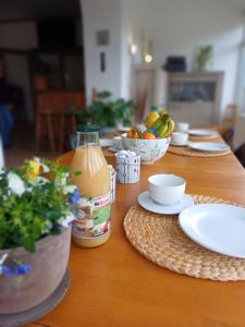 ラ・ロシュ・アン・アルデンヌにあるGite Villa le Monde - La Roche-en-Ardenneの木製テーブル(皿料理、オレンジジュース入)