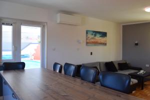 een woonkamer met een tafel, stoelen en een bank bij Holiday House Risika Seaview in Risika