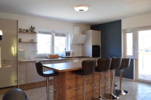 een keuken met een houten aanrecht en barkrukken bij Holiday House Risika Seaview in Risika +16 foto's