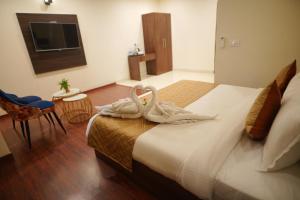 dois cisnes sentados numa cama num quarto de hotel em Comfort Inn Karnal em Tirāwari