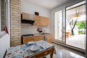 a kitchen with a table and a kitchen with a window at Villa Ada Depandance 1 in Punta Prosciutto
