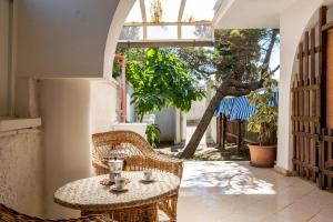 a table and chairs on a patio with a tree at Villa Ada Depandance 1 in Punta Prosciutto