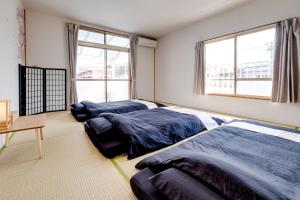 松本市にあるForest Agataのベッドルーム1室(ベッド2台、テーブル、窓付)