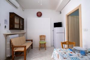 a room with a table and chairs and a refrigerator at Villa Ada Depandance 1 in Punta Prosciutto