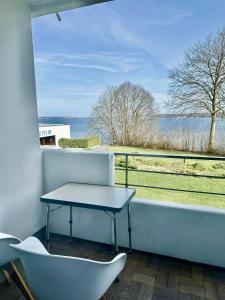 キールにあるAppartement mit traumhaftem Kieler Förde Blickのテーブルと椅子、景色を望むバルコニー