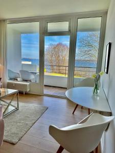 ein Wohnzimmer mit einem Tisch und Stühlen in der Unterkunft Appartement mit traumhaftem Kieler Förde Blick in Kiel
