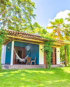 a house with a hammock in the yard at Angá Beach Hotel in São Miguel dos Milagres