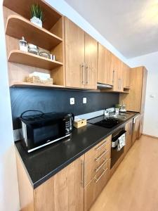 a kitchen with a microwave and a black counter top at Apartment Tina - Old Town, Free Private Parking in Bratislava