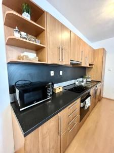 cocina con microondas y encimera negra en Apartment Tina - Old Town, AC, Free Private Parking, en Bratislava