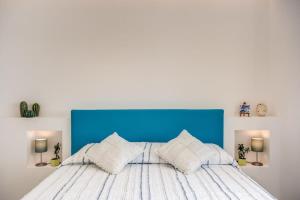 um quarto com uma cama com uma cabeceira e almofadas azuis em Relais Mamma Mia em Massa Lubrense