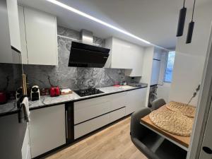a kitchen with white cabinets and a counter top at Como en casa! in Alfafar