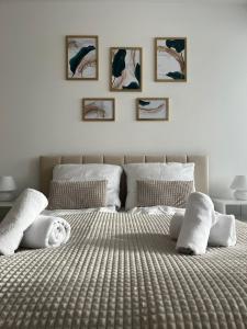 - une chambre avec un grand lit et 4 photos sur le mur dans l'établissement Apartament Planeta 106 - tylko 100 m od plaży, à Mielno