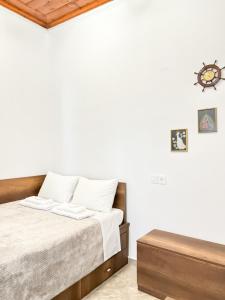 a white bedroom with a bed and a table at La Casa di villagio in Koskinou +33 photos