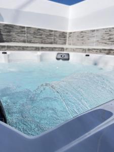 a bath tub filled with blue water in a room at La Casa di villagio in Koskinou