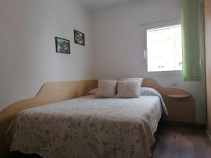 una camera da letto con un letto con due cuscini e una finestra di Casa Paraiso a Almería